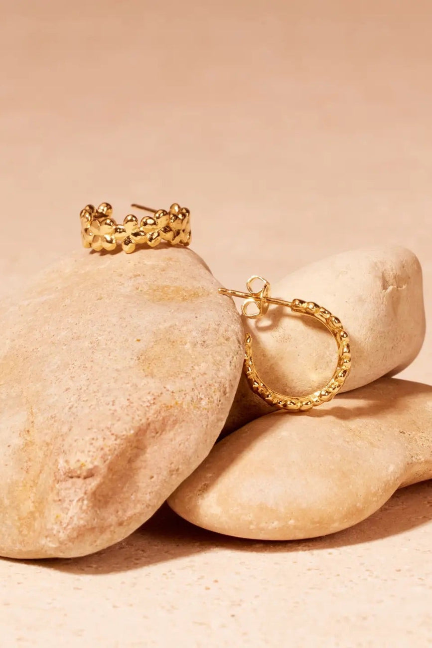 Gold rings on stones with a beige background